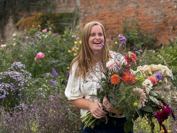 Harriet from Best Buds Flowers holding a freshly picked bouquet of seasonal flowers. 